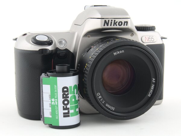 Step by step instructions with pictures on how to load 35mm film into the Nikon N65. Start taking photos with your Nikon N65 camera today.